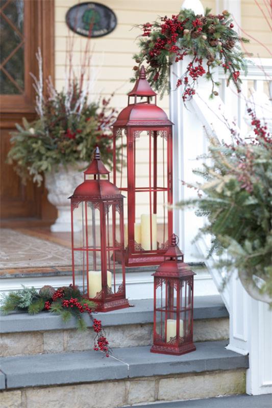 Lyhdyt Joulukoristeita sisälle ja ulos kolme tummanpunaista metallilyhtyä talon sisäänkäynnin edessä portaissa valkoiset kynttilät punaiset marjat