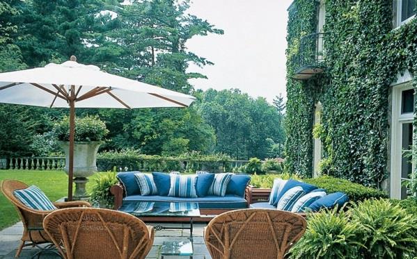 Lounge -huonekalut puutarhassa aurinkovarjoja
