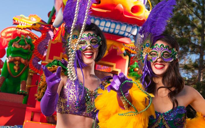 Mardi Gras -karnevaalijuhlat Amerikansichissa kaksi naista pukeutui klassisiin väreihin violetti kullankeltainen vihreä