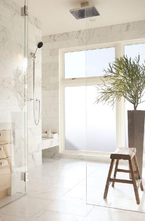 Marmori kylpyhuoneessa marmorilaatat kylpyhuone suunnittelu beige lasiseinä puinen jakkara kasvi paljon valoa