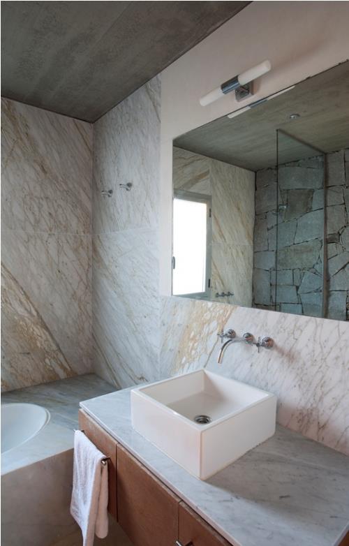 Marmori kylpyhuoneessa marmorilaatat kylpyamme turhamaisuuspeili aksenttiseinä peilissä lasiseinässä