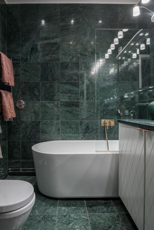 Marmori kylpyhuoneessa Marmorilaatat smaragdinvihreä ja valkoinen valaistu kontrastina