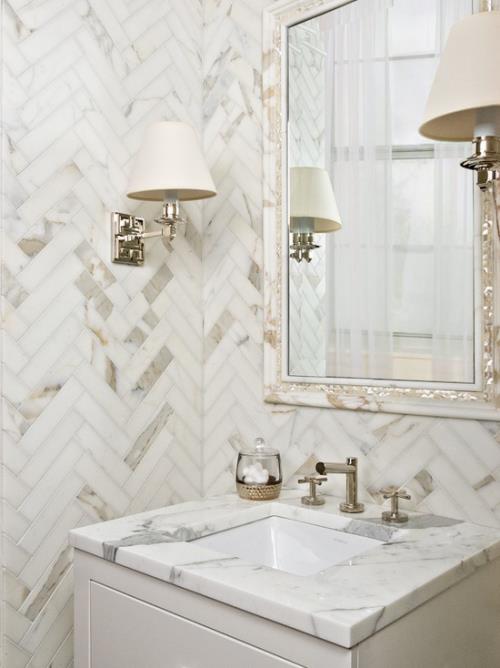 Marmori kylpyhuoneessa Marmorilaatat kulmassa modernissa kylpyhuoneessa Seinävalaisin, peili, turhamaisuus vaaleanharmaa