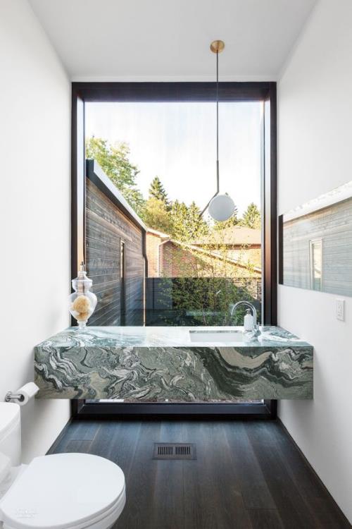 Marmori kylpyhuoneessa marmorilaatat iso ikkuna smaragdinvihreä kylpyamme valkoinen kylpyhuonekalusteet ylellinen muotoilu
