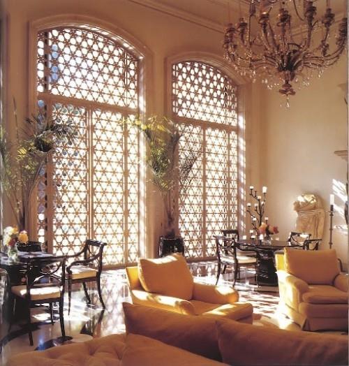 Marokkolaiset kalusteet, joissa on leveät kattoon ulottuvat ikkunat ja puupalkit