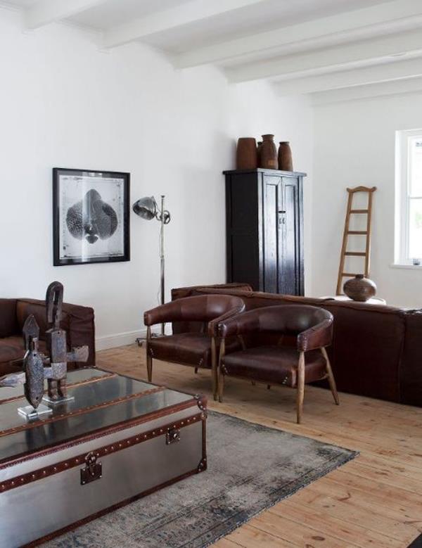 Maskuliininen ja tyylikäs moderni olohuone luonnolliset yksinkertaiset kalusteet kaksi nahkaista nojatuolia, joissa on paljon vaaleita koristehahmoja