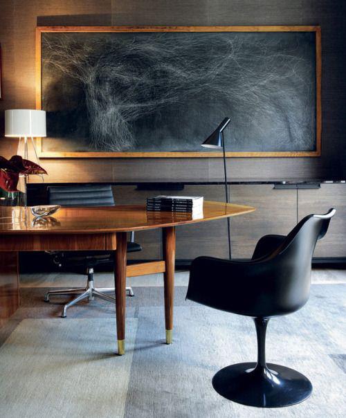 Maskuliininen kotitoimisto iso pöytä musta nojatuolilamput tumma seinämaalaus