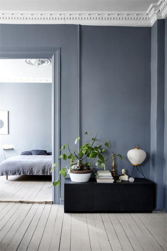 Tuo enemmän väriä sisustukseen Yhtenäinen suunnittelukonsepti Makuuhuone taustalla harmaa puulattia Sininen hallitsee seinän väriä