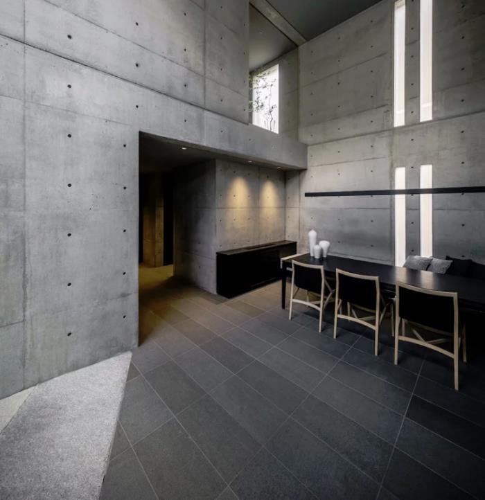 Minimalistinen talo kivestä ja betonista Japanissa Puhdasta minimalismia sisätiloissa ruokasalissa leveän huoneen kerroskalusteet päivänvalo