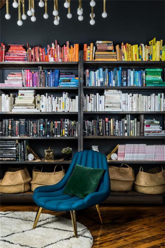Moderni kotikirjasto sininen nojatuoli kirjahylly kirjat järjestää väreittäin