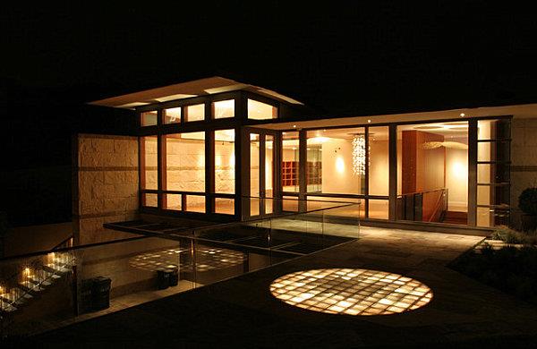 Modernit huoneet, joissa on lasilohko yöllä lasisen julkisivun ulkopuolella