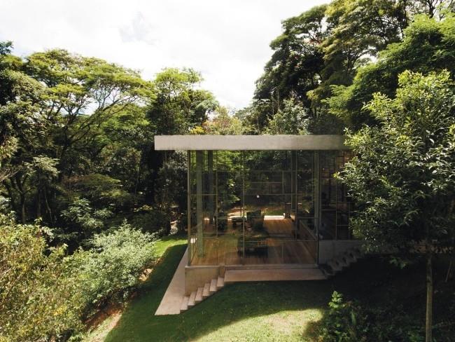Moderni talo, joka on valmistettu lasista ja betonista sademetsässä ja joka on rakennettu yksinkertaisesti suunnitteluun näppärästi toteutettuna