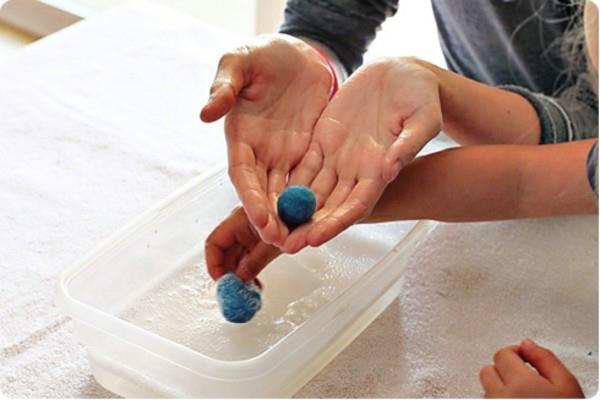 Märkähuovutus lasten huovuttaessa villahuopapalloja vettä