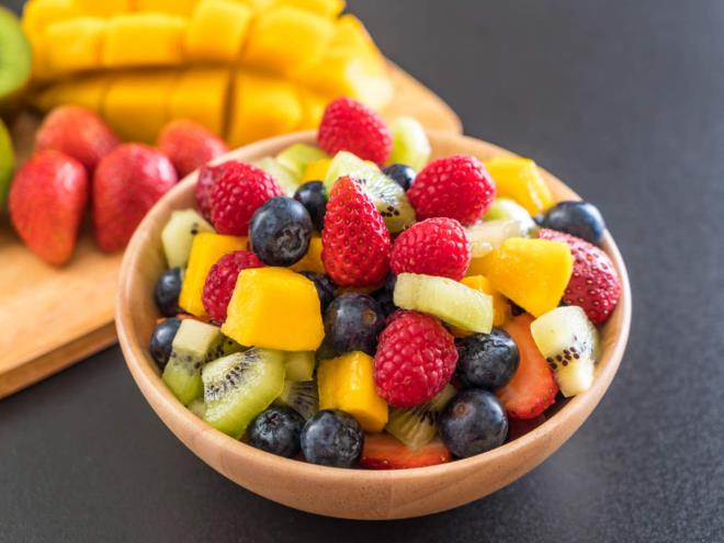 Syöminen hedelmiä terveellisiä laihdutuskuoria tuoreita hedelmiä mansikoita mustikoita ananasta kiiviä paloiteltuna