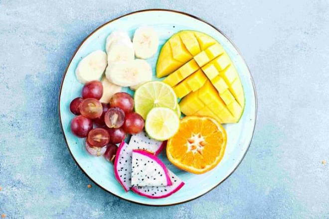 Syö hedelmiä terveellisesti laihduta illalla, vältä hedelmiä lautasella ananas appelsiinit banaani viipaloidut viinirypäleet