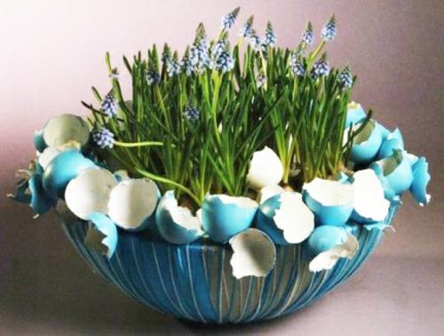 Pääsiäiskoriste kevään kukkien kimpussa munankuoret sininen