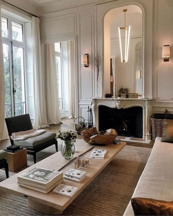 Pariisin tyylikäs olohuoneessa houkutteleva tunnelma peili takan yläpuolella suuri ikkuna paljon valokirjoja sohvapöydällä