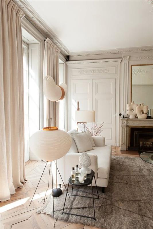 Pariisin tyylikäs olohuoneessa valkoiset seinät vaaleanharmaa matto valkoinen sohvalamppu takka peili koriste -esineitä
