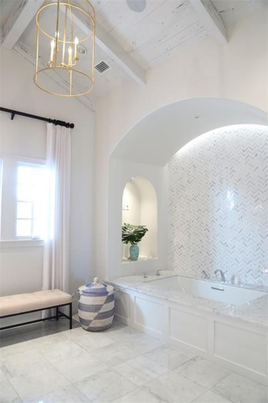 Oikea kylpyhuonevalo on erittäin moderni ja hyvin valaistu.Sisäänrakennettu valaistus, kylpyamme, ikkuna, luonnonvalo