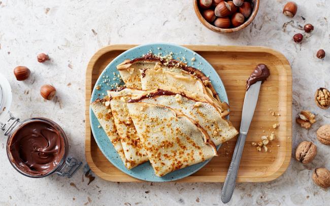 Pannukakut helppo taittaa lautaselle, tarjoillaan Nutellan ja pähkinöiden kanssa