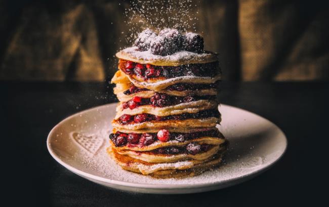 Pannukakkuista tuli helppoja herkullisia pannukakkuja, jotka oli pinottu lautaselle tuoreilla marjoilla ja tomusokerilla