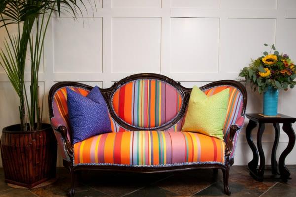 Pehmustetut huonekalut ja värikäs raidallinen eklektinen sohva