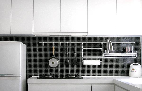 Käytännöllisiä keittiötarvikkeita koristeena valkoiset huonekalut mosaiikki takaseinä