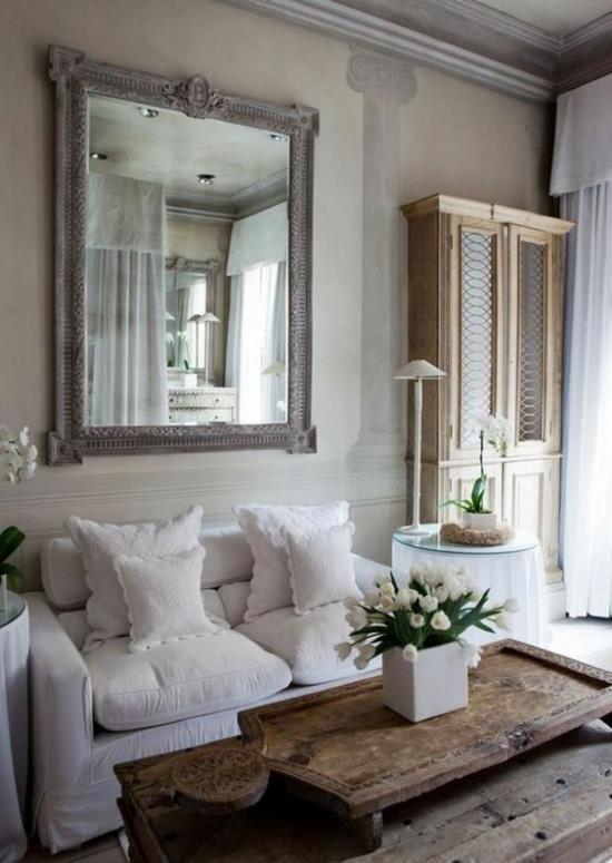 Provencen tyyli kodikas olohuone romanttinen sisustus mukavat huonekalut valkoiset peitot tyynyt puinen pöytä valkoinen tulppaanit seinäpeili