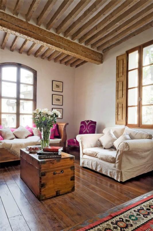 Provence -tyyliset klassiset huonekalut kodikas huonesuunnittelu puinen rintakehä pöytä maljakoina kukilla erittäin houkutteleva tunnelma aksentteja viininpunaisena
