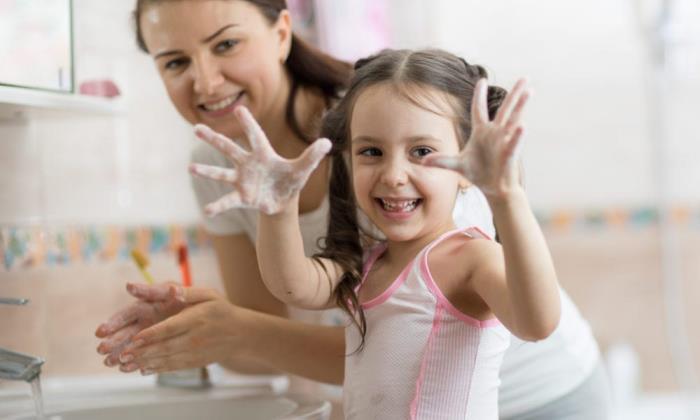 Oikea käsienpesu äitilapsi kylpyhuoneessa pesee kädet