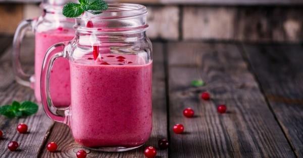 Vaaleanpunainen smoothie, joka on valmistettu karpaloista lasissa Smoothiet tekevät sinusta hoikkaan ja terveen