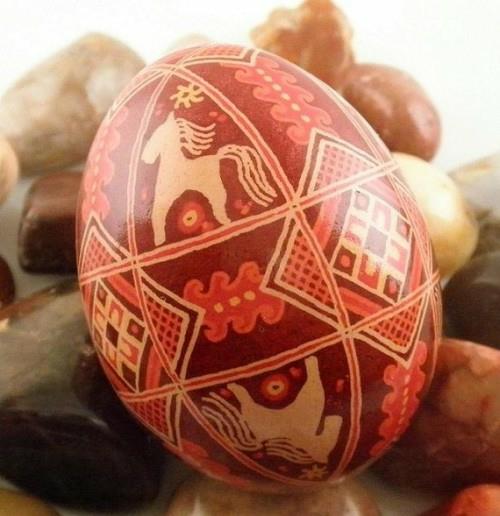 Punaiset pääsiäismunat maalataan puukanamalliseksi koristeltuna