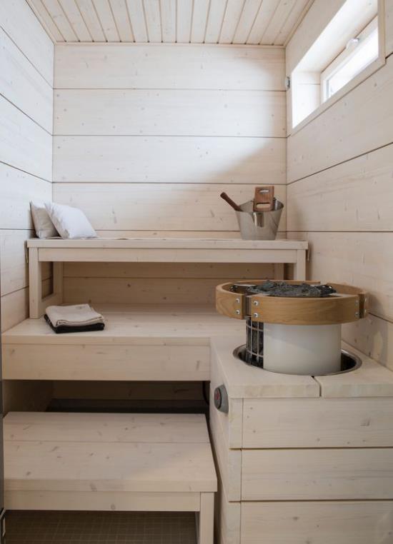 Retrotyylinen sauna kotona vaaleasta puusta, pyyhkeet, kylpyammeet, ikkuna