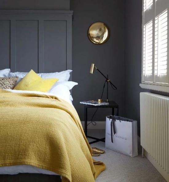 Makuuhuoneen ideoita harmaalla ja keltaisella rohkea väriyhdistelmä grafiitinharmaa seinä vaaleankeltainen päiväpeitelamppu sängyn vieressä