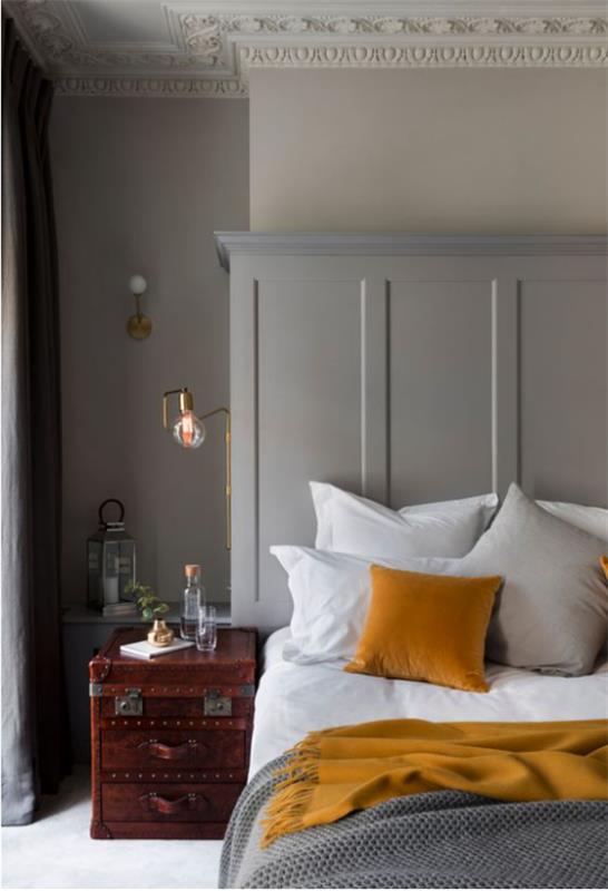 Makuuhuoneideoita harmaassa ja keltaisessa yksinkertaisessa huoneen sisustuksessa vanha matkalaukku yöpöytänä valkoiset vuodevaatteet harmaa viltti keltainen tyyny