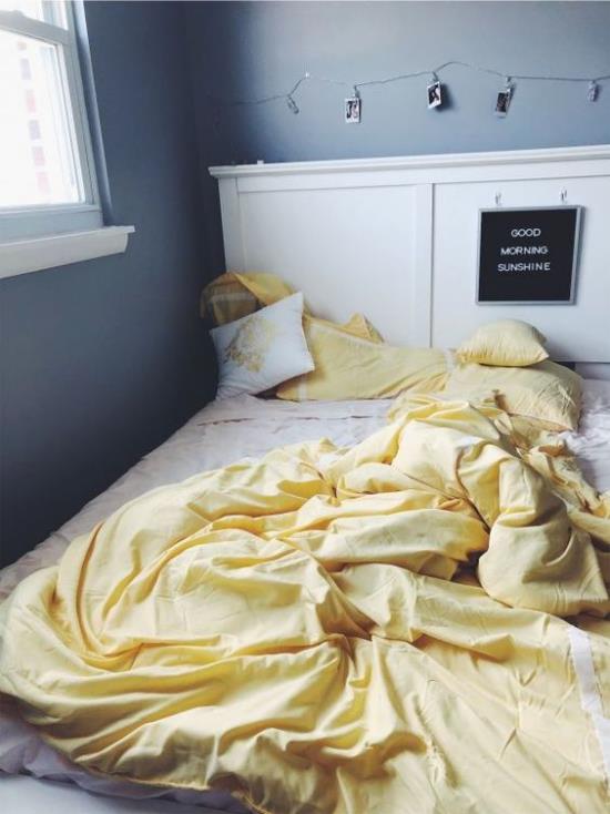 Makuuhuoneideoita harmaassa ja keltaisessa sängyssä valkoiset vuodevaatteet vaaleankeltainen viltti tummanharmaat seinät ikkunat