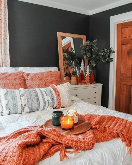 Makuuhuoneen syksyinen suunnittelu Kontrasti tumma seinä mustanvihreässä liinavaatteessa valkoisena Heittohuopa lohenvärisenä Puutyynyt huonekasvi