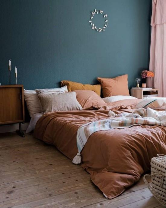 Makuuhuoneessa on syksyinen sinivihreä seinä korostavina vuodevaatteina