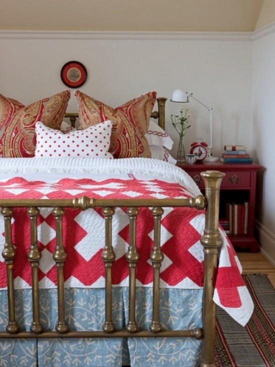 Makuuhuoneen syksyinen muotoilu maalaismainen tunnelma vuodevaatteet puna -valkoisissa kuvioiduissa tyynyissä yöpöytälamppukirjat