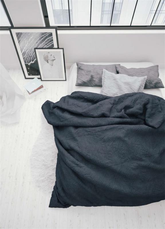 Makuuhuoneen minimalistinen kolme väriä hallitsee valkoista harmaata mustaa sänkyä