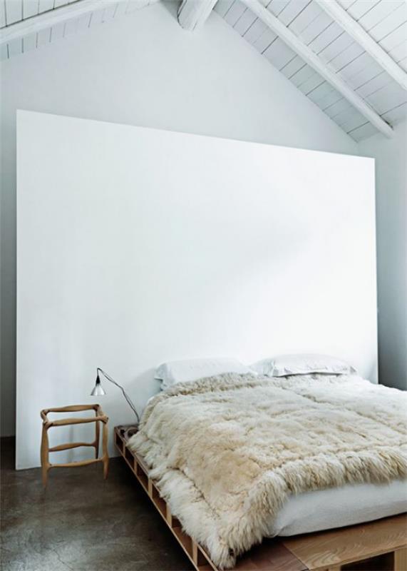 Makuuhuoneen minimalistinen sisustus maalaismaisia ​​elementtejä huonesuunnittelussa heittää huovan villapalkkeista kattoon