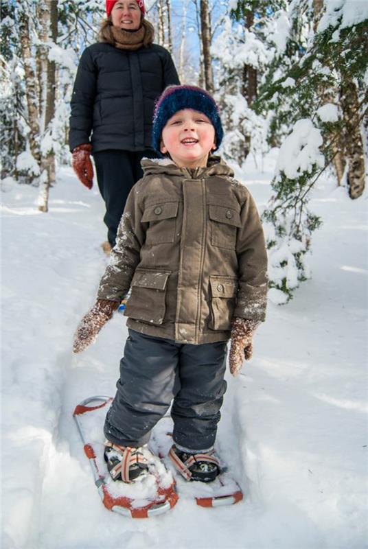 Lumikenkälapset patikoimassa lumessa