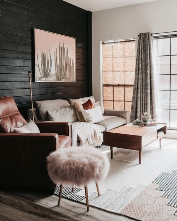 Musta seinä kodikas olohuone maalaus sohvalla nojatuoli ottomaanityyny vaaleanpunainen beige harmaa