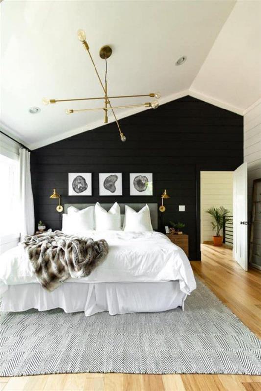 Musta seinä makuuhuoneessa epäsymmetrisesti nukkumissängyn takana kolme kuvaa seinävalaisimet tyylikäs sisustus
