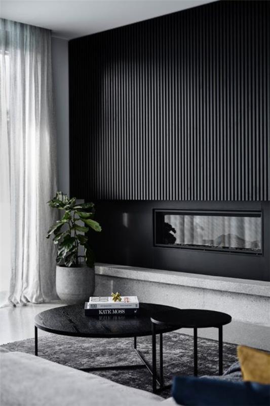 Olohuoneen musta seinä korostaa visuaalisesti yksittäisiä alueita yhdistettynä paljon harmaaseen