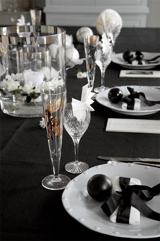 Juhli uudenvuodenaattoa kotona mustana mieluisin värinen pöytäliina koristelu valkoiset posliini kristallilasit