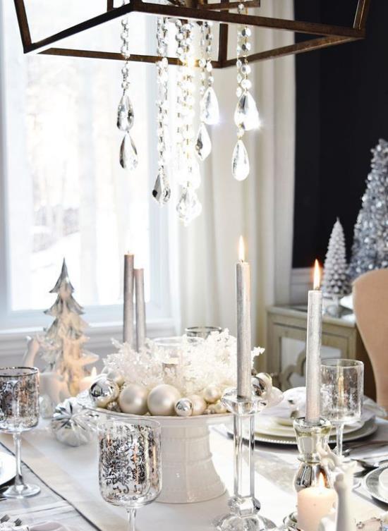 Juhli uudenvuodenaattoa kotona juhlallisesti katettu pöytä, roikkuvat kiteet, kimaltelevat lasit, kynttilät, hieno järjestely pöydän keskellä hopeaa