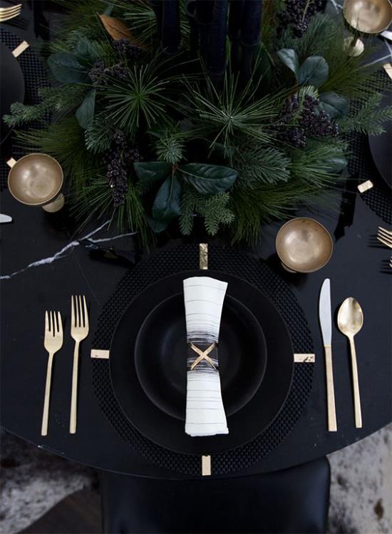 Juhli uudenvuodenaattoa kotona juhlapöytä musta pöytäliina musta palvelu kultaiset kimaltelevat ruokailuvälineet vihreitä pöydän keskellä