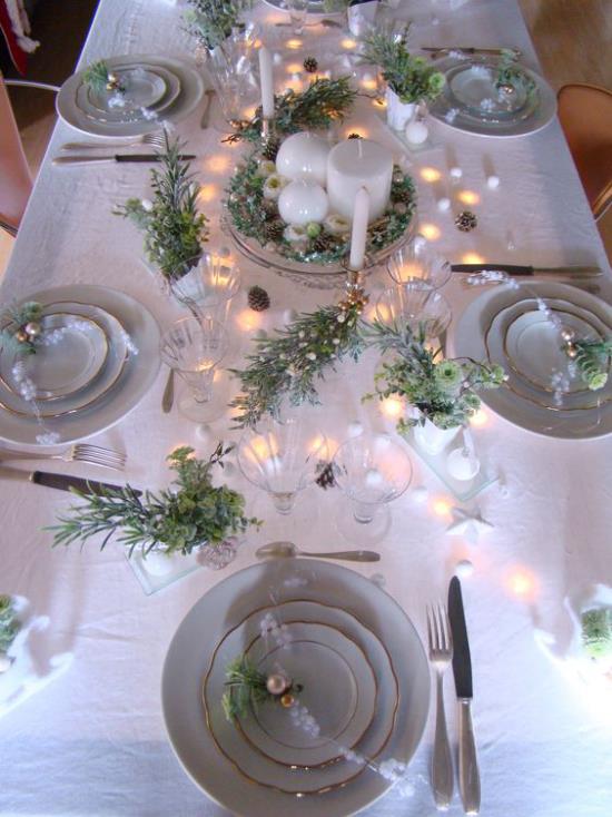 Juhli uudenvuodenaattoa kotona juhlapöytä valkoinen pöytäliina posliini palvelu pienet valot vihreä rosmariini