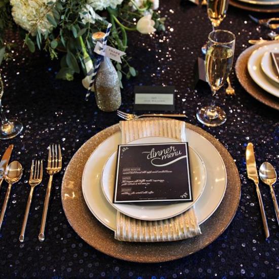Juhli uudenvuodenaattoa kotipöydässä kattaen mustat pöytäliinat kultaiset kimaltavat hienot ruokailuvälineet myös kultaa